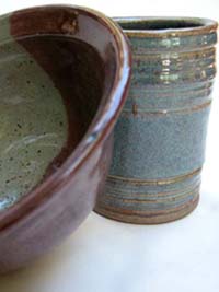 Red bowl leaning up against Blue Mug
